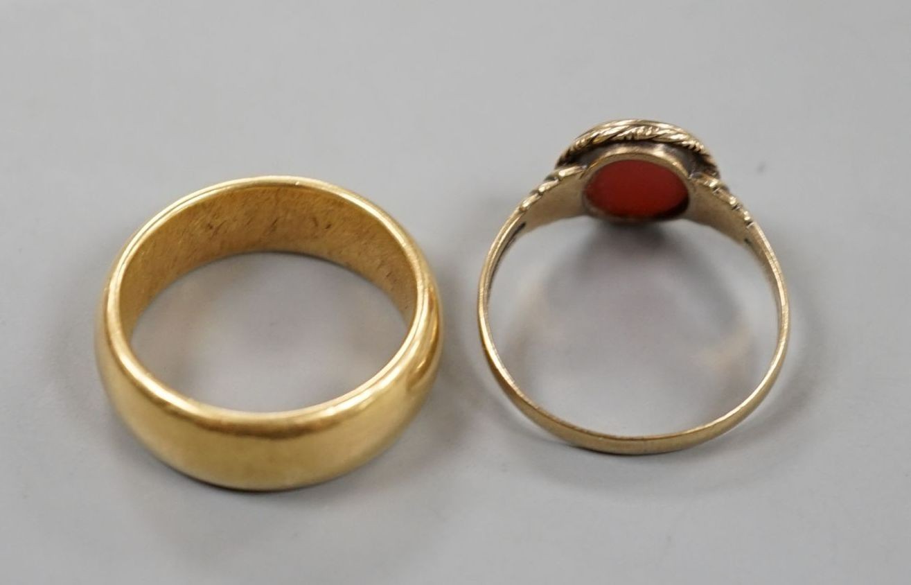 A George V 18ct gold wedding band, size Q, 14 grams and a 333 standard yellow metal and carnelian set signet ring, size R, gross weight 2.8 grams.